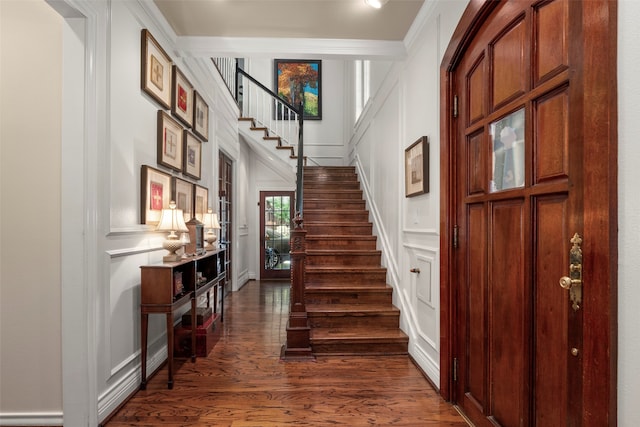 entrance foyer featuring ornamental molding and dark hardwood / wood-style flooring