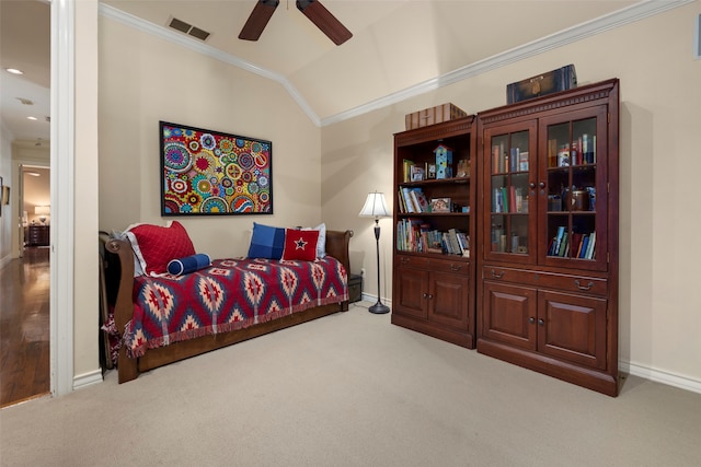 carpeted bedroom with lofted ceiling, crown molding, and ceiling fan