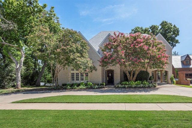 view of front of house with french doors and a front lawn