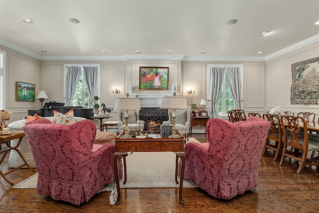 living room with ornamental molding, wood-type flooring, and a healthy amount of sunlight