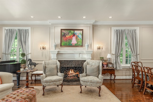 living area featuring ornamental molding, dark hardwood / wood-style flooring, plenty of natural light, and a fireplace