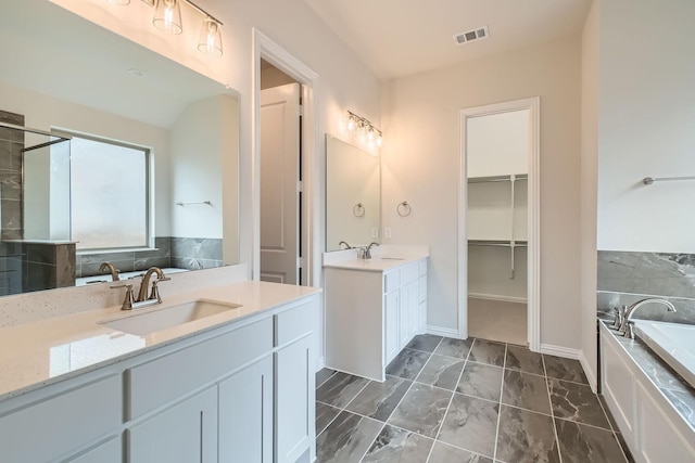 bathroom featuring vanity and a bath