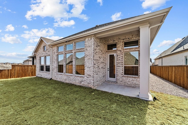 rear view of house featuring a patio area and a lawn