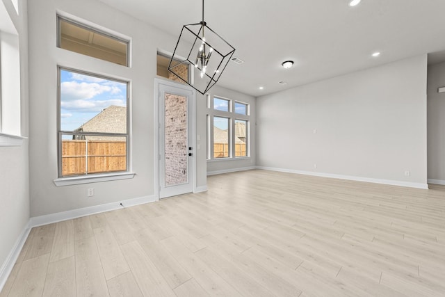 interior space featuring light hardwood / wood-style flooring and a notable chandelier