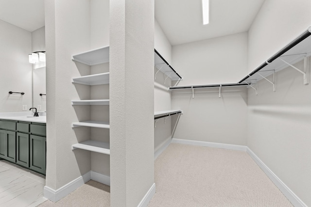 walk in closet with sink and light carpet