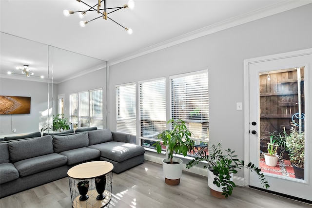 living room with crown molding, light hardwood / wood-style flooring, and a chandelier