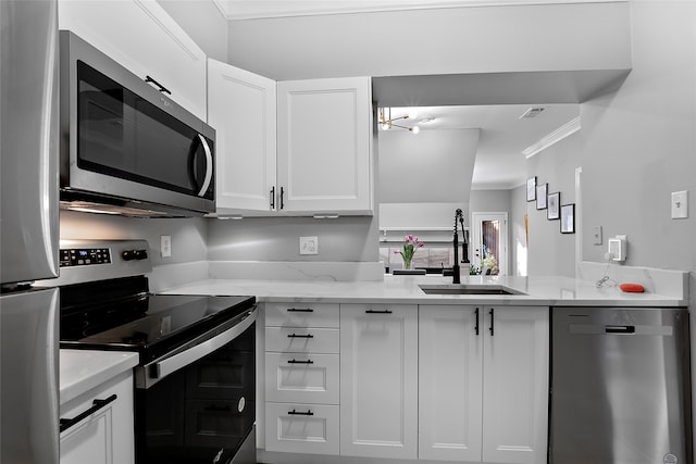 kitchen with crown molding, appliances with stainless steel finishes, sink, white cabinets, and light stone counters