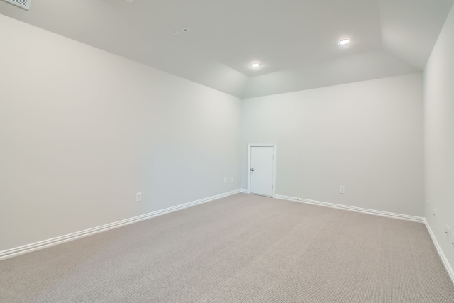 carpeted spare room featuring lofted ceiling