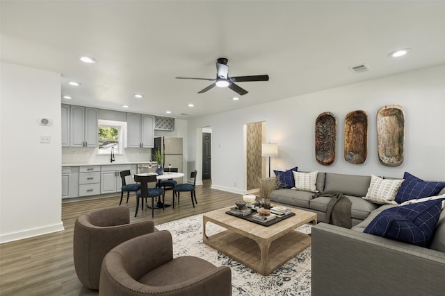 living room featuring ceiling fan, hardwood / wood-style flooring, and sink