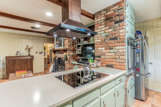 kitchen with light tile patterned floors, island range hood, a fireplace, stainless steel fridge, and black electric stovetop