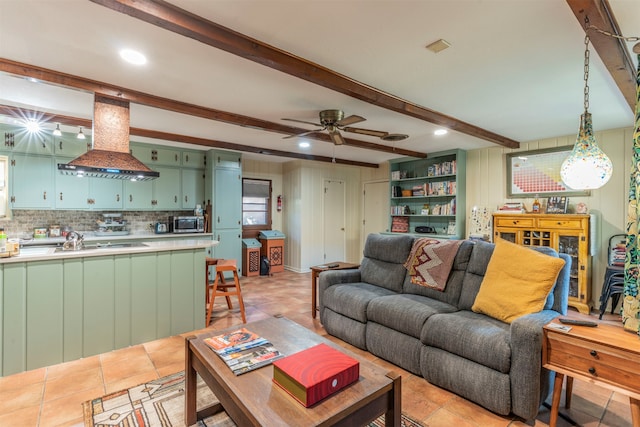 tiled living room featuring sink, ceiling fan, and beam ceiling