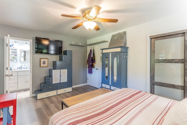 bedroom featuring hardwood / wood-style flooring, ceiling fan, and connected bathroom