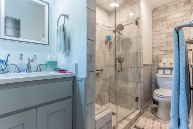 bathroom featuring walk in shower, tile walls, vanity, and toilet