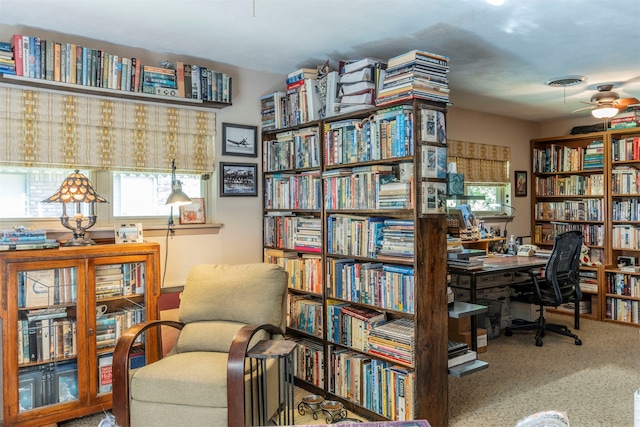 carpeted home office featuring ceiling fan