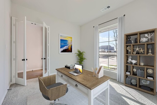 carpeted office with a wealth of natural light and french doors