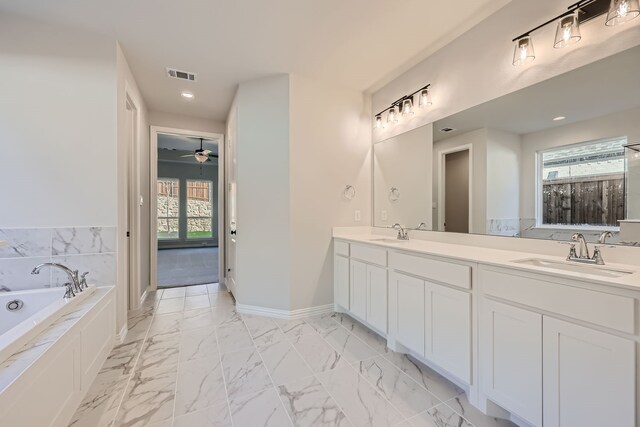 bathroom featuring vanity, a tub to relax in, plenty of natural light, and ceiling fan