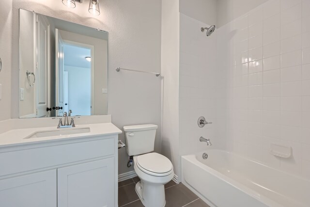 full bathroom featuring vanity, tiled shower / bath combo, tile patterned floors, and toilet