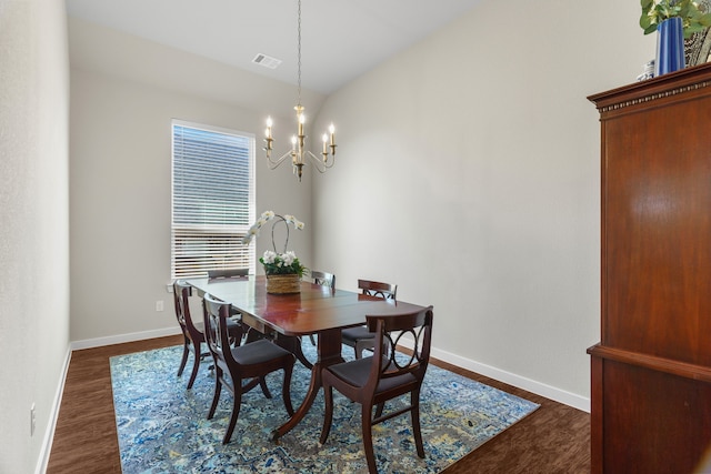 dining area with vaulted ceiling, dark hardwood / wood-style floors, and a notable chandelier