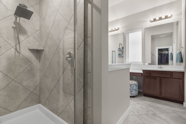 bathroom featuring tile patterned flooring, vanity, and tiled shower