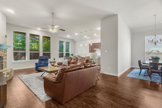 living room featuring a fireplace, dark hardwood / wood-style floors, and ceiling fan with notable chandelier