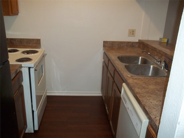 kitchen featuring dark wood-type flooring, sink, and white appliances