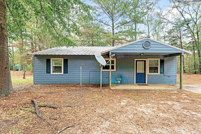 ranch-style house featuring covered porch and metal roof