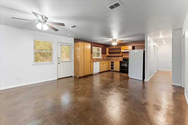 unfurnished living room with finished concrete flooring, a healthy amount of sunlight, and visible vents