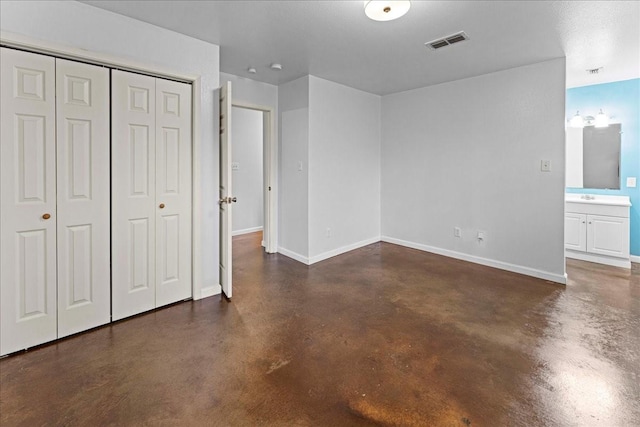 unfurnished bedroom featuring baseboards, finished concrete floors, visible vents, and a closet