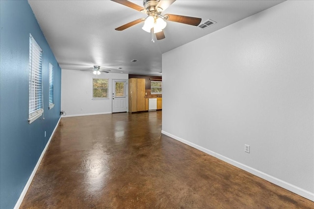 spare room with visible vents, ceiling fan, finished concrete flooring, and baseboards