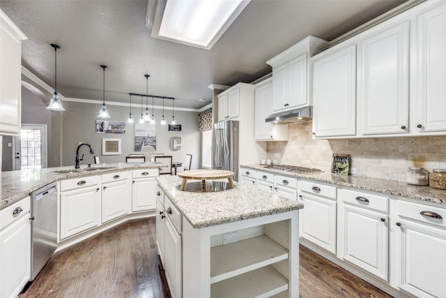 kitchen featuring hanging light fixtures, ornamental molding, white cabinets, appliances with stainless steel finishes, and dark hardwood / wood-style flooring