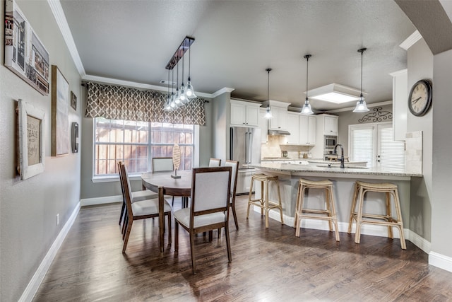 dining space featuring a wealth of natural light, sink, and dark wood-type flooring