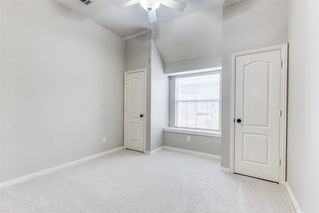 unfurnished bedroom featuring lofted ceiling, light colored carpet, and ceiling fan