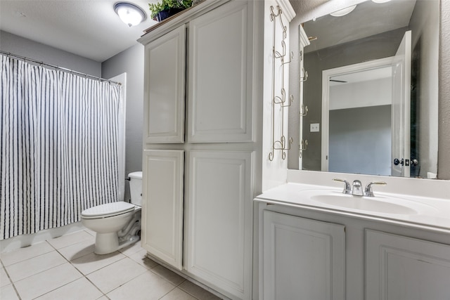 bathroom featuring walk in shower, vanity, toilet, and tile patterned flooring