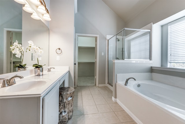 bathroom featuring vanity, separate shower and tub, vaulted ceiling, and tile patterned floors