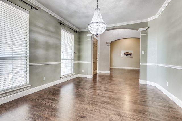 empty room with crown molding, dark hardwood / wood-style flooring, and a chandelier