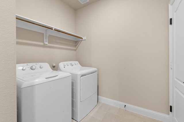 laundry room with independent washer and dryer and light tile patterned floors