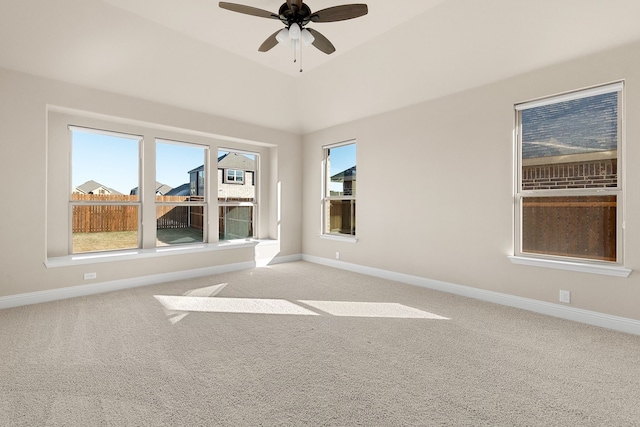 spare room featuring light carpet, vaulted ceiling, and ceiling fan