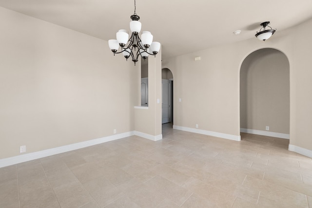 spare room featuring a chandelier and light tile patterned floors