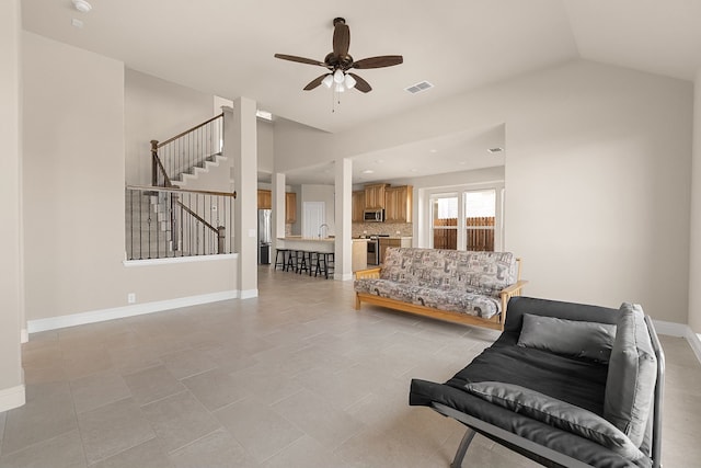 tiled living room with sink, vaulted ceiling, and ceiling fan