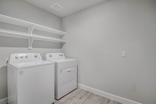 laundry room featuring light hardwood / wood-style floors and separate washer and dryer