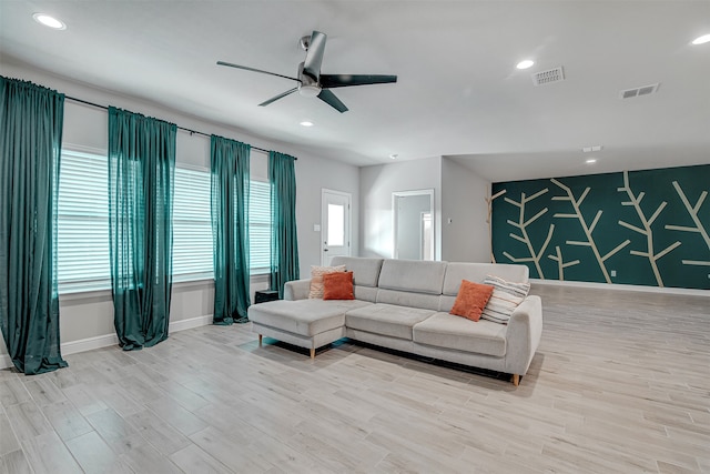 living room featuring light hardwood / wood-style flooring, a healthy amount of sunlight, and ceiling fan