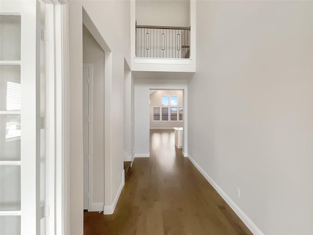 corridor with baseboards and wood finished floors