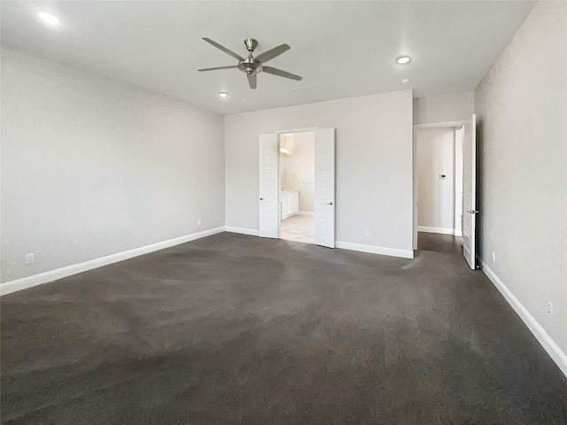 unfurnished bedroom featuring dark carpet, ensuite bathroom, recessed lighting, and baseboards