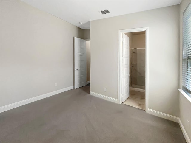 unfurnished bedroom featuring carpet, visible vents, and baseboards