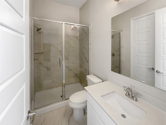 bathroom featuring toilet, a shower with shower door, and vanity