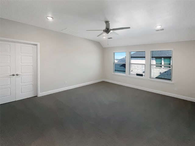 spare room with dark colored carpet and ceiling fan