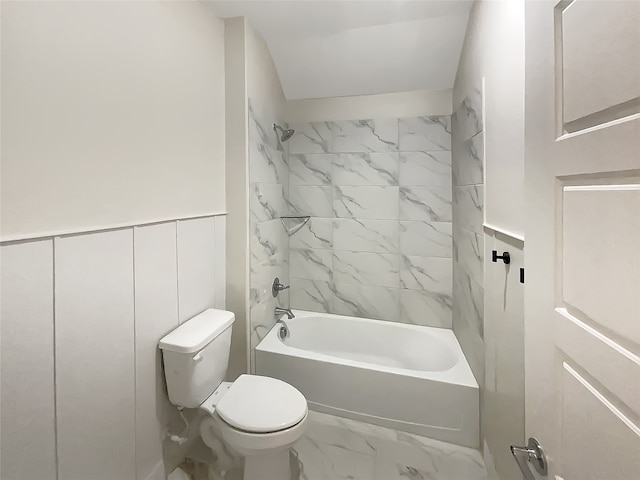 bathroom with tiled shower / bath combo and toilet