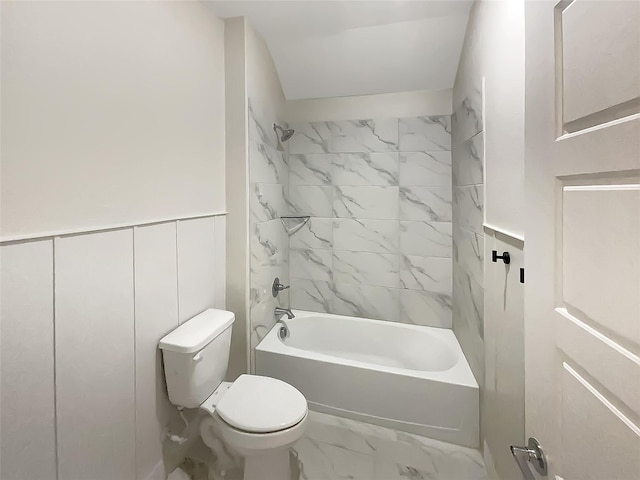 bathroom featuring bathing tub / shower combination, toilet, and marble finish floor