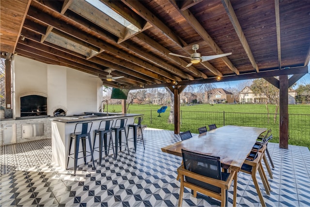 view of patio / terrace featuring area for grilling, ceiling fan, and an outdoor bar