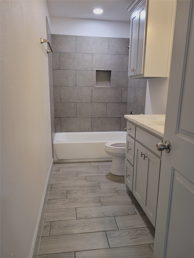 full bathroom featuring vanity, tiled shower / bath combo, and toilet